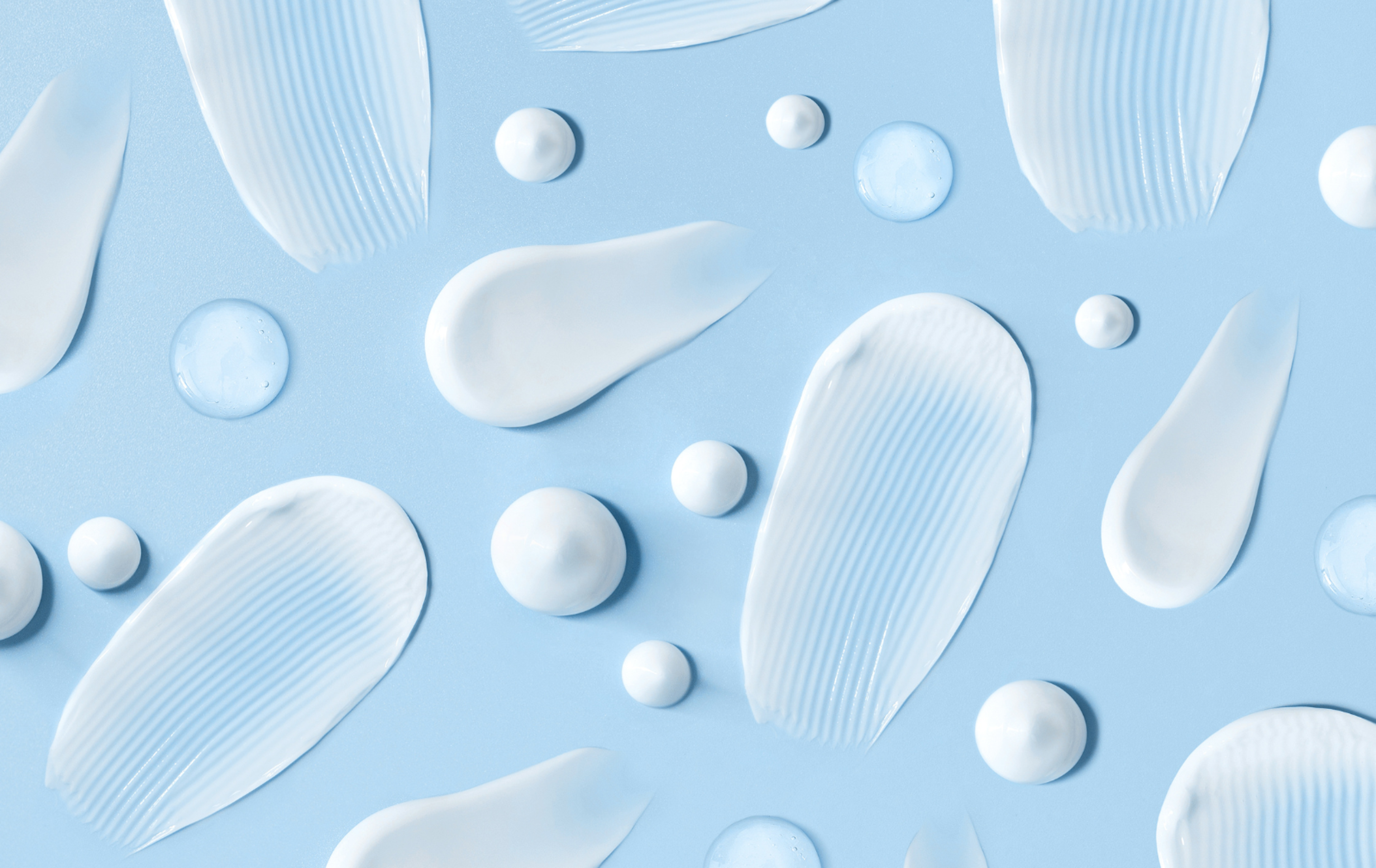 A collection of lotion smears set on a blue background